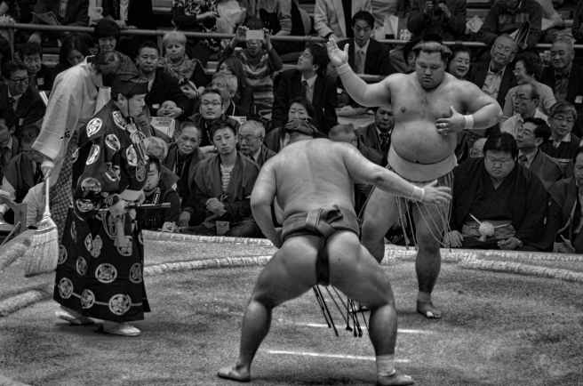 grayscale photo of sumo wrestling surrounded with people